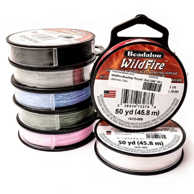 WildFire thread by PotomacBeads A stack of colorful spools of Beadalon WildFire beading thread. The front spool is red, showing the brand name and details of the strong, braided thermal-bonded thread.