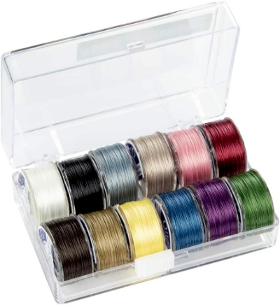 TOHO One-G thread A clear plastic organizer box opened to show a colorful set of TOHO One-G beading thread spools. The set displays a wide palette of colors for matching with beads.